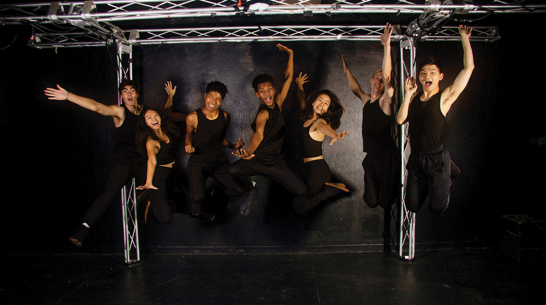 Image of Gendo Taiko students dressed in black jumping up.