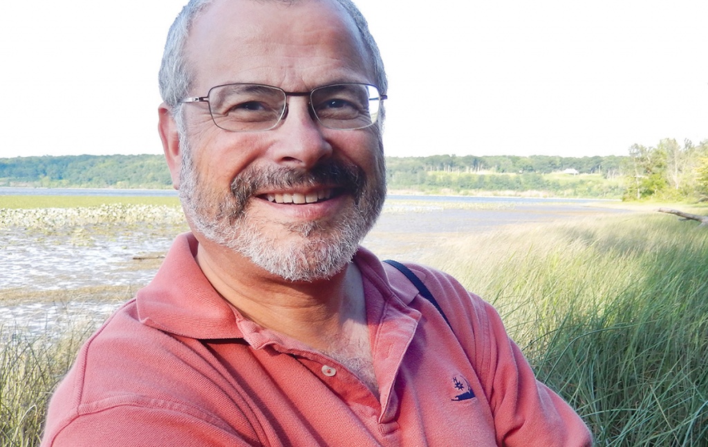 Photo of Joel Scheraga, with wetlands in the background.