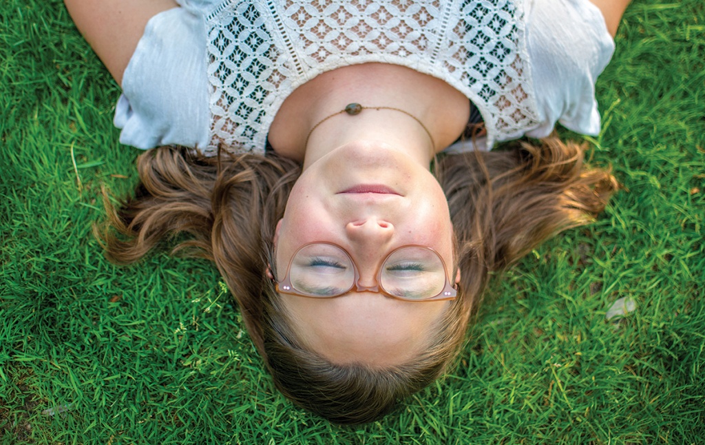 A student rests on the grass