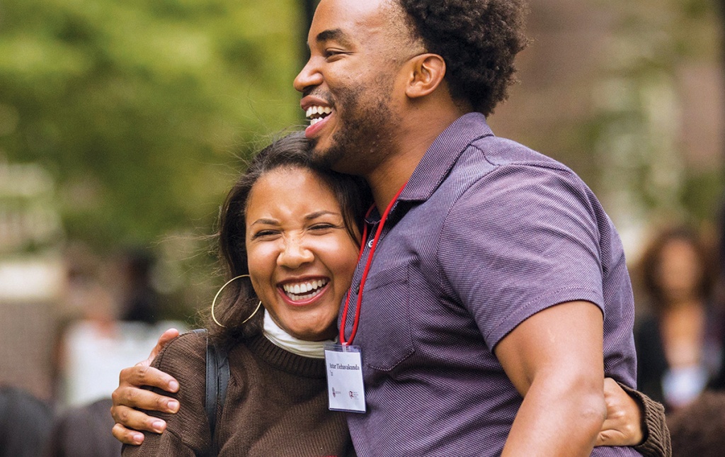 Two people greeting each other at the Black Alumni reunion.