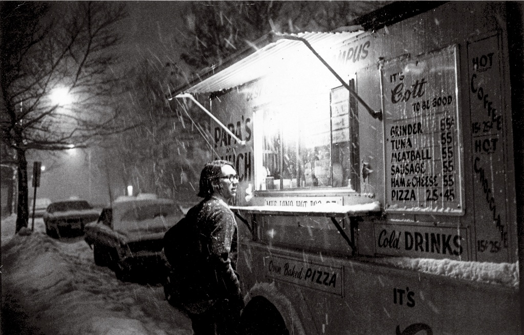 Archive photo of a student standing in front of a food truck in the snow.