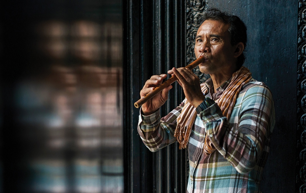 portrait of Arn Chorn Pond playing the flute