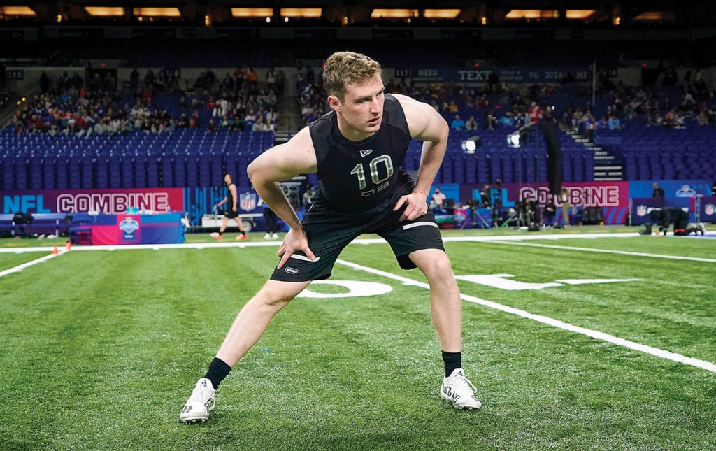 Image of EJ Perry stretching on football field