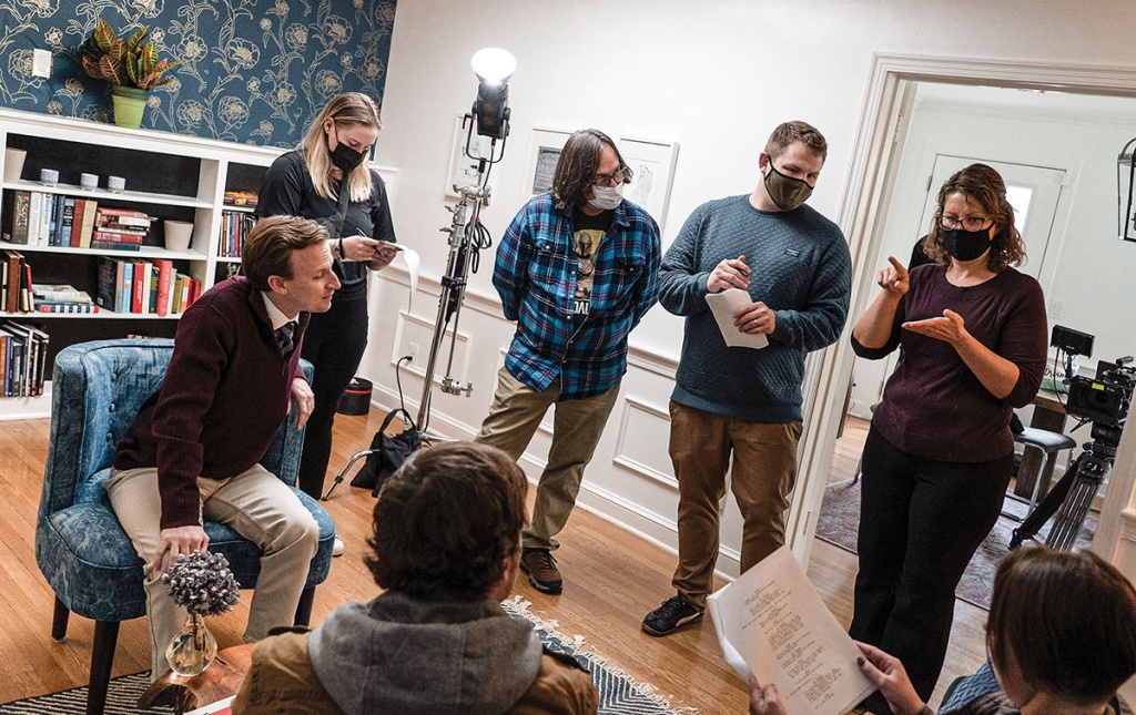 Image of Peter Kimball on set of Millstone with cast and crew listening to ASL interpreter