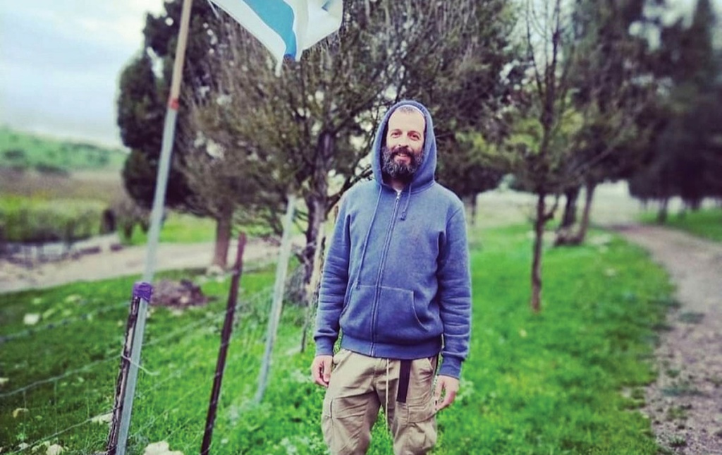 Image of Akiva Gersh standing next to the Israeli flag