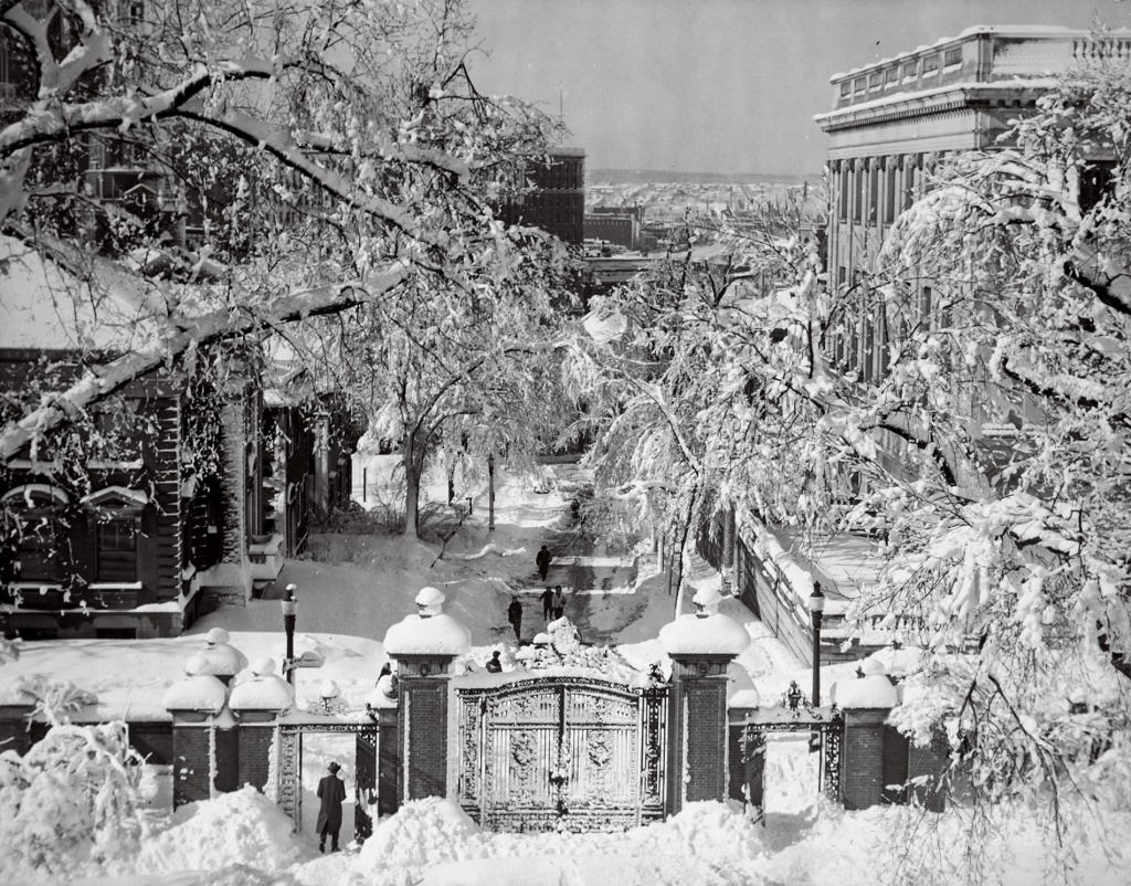 Image of Brown University's Van Wickle gates in the snow in the early-20th century, looking down College Hill.