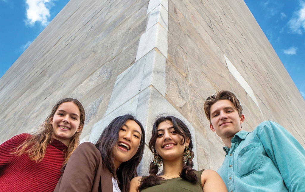 Image of Isabelle Sharon ’23.5, Alice  Im ’24, Ruhma Khawaja ’24, and author Peder Schaefer ’22.5 at the base of the Washington Monument.