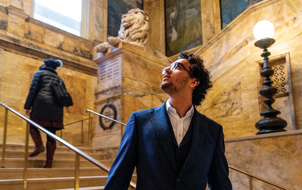 Image of Karim Zohdy looking up in the stairwell of the Boston Public Library