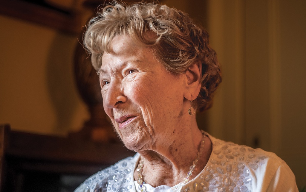 Image of Lillian Affleck looking out a window with a smile on her face.