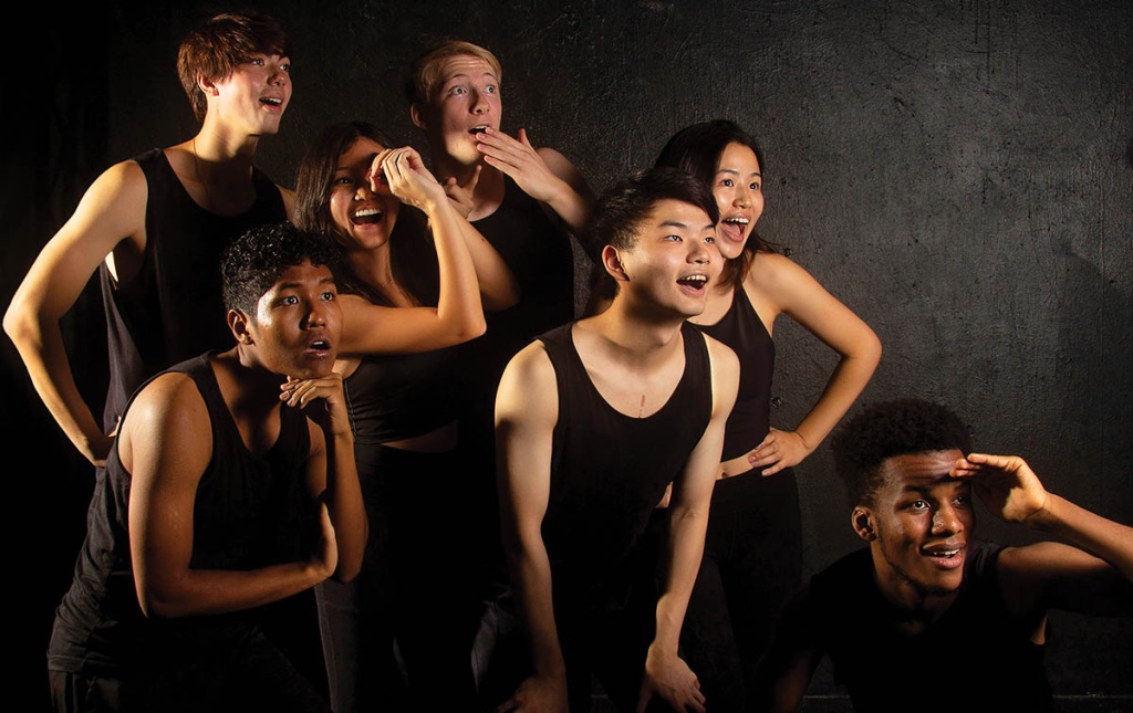 Image of Gendo Taiko drummers dressed in black all looking off to the side making silly expressions.