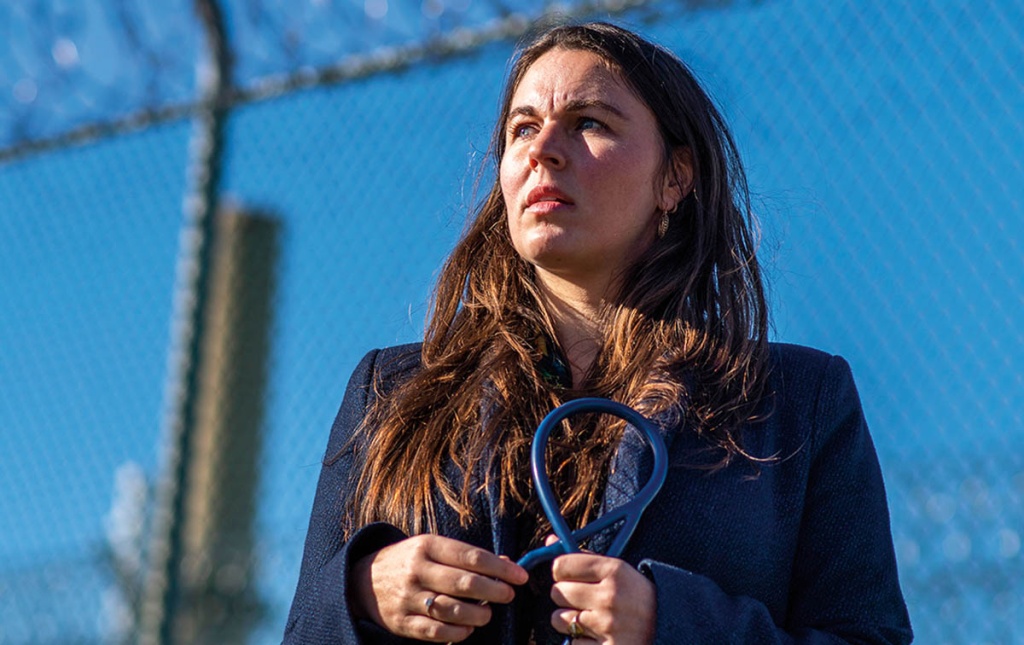 An image of Rachel Bedard holding a stethoscope outside of a prison