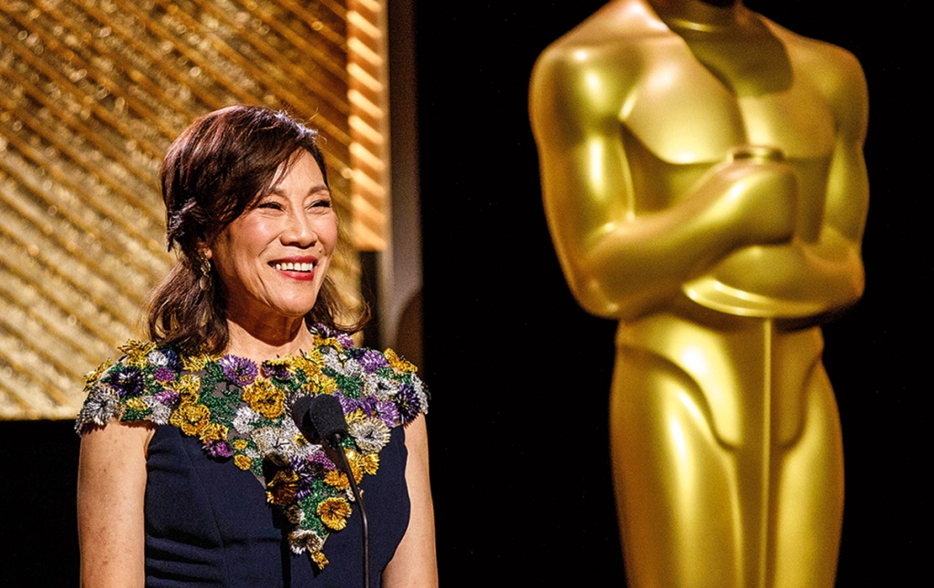 Image of Janet Yang on stage at the Academy Awards with the life-sized Oscar behind her
