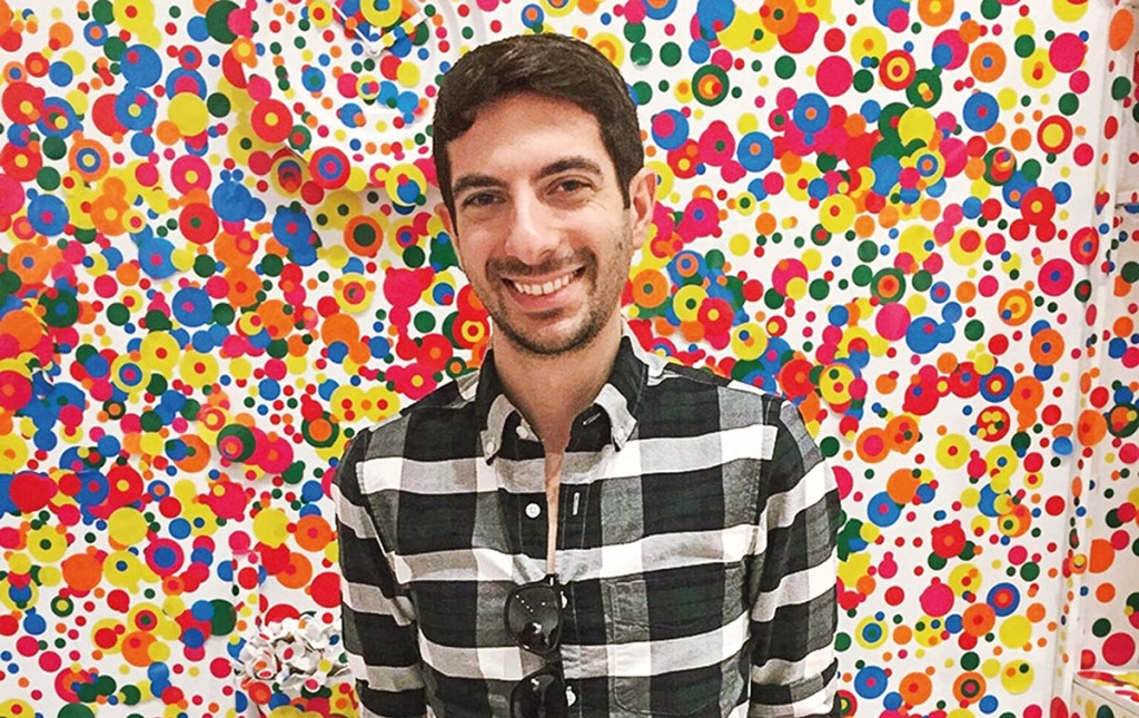 Image of David Pagliaccio standing in front of a colorful wall. 