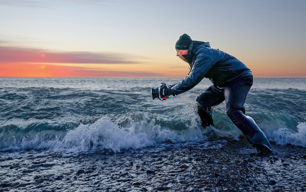 Image of Steven Koppel taking a photo in the surf.