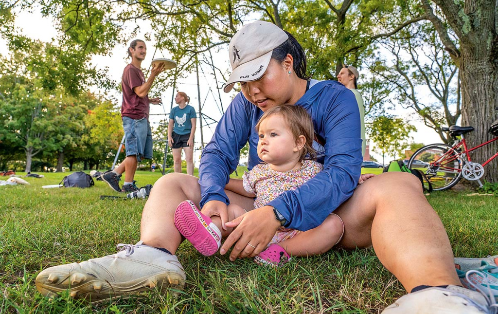 Image of a mother sitting on the ground with her baby in front of her