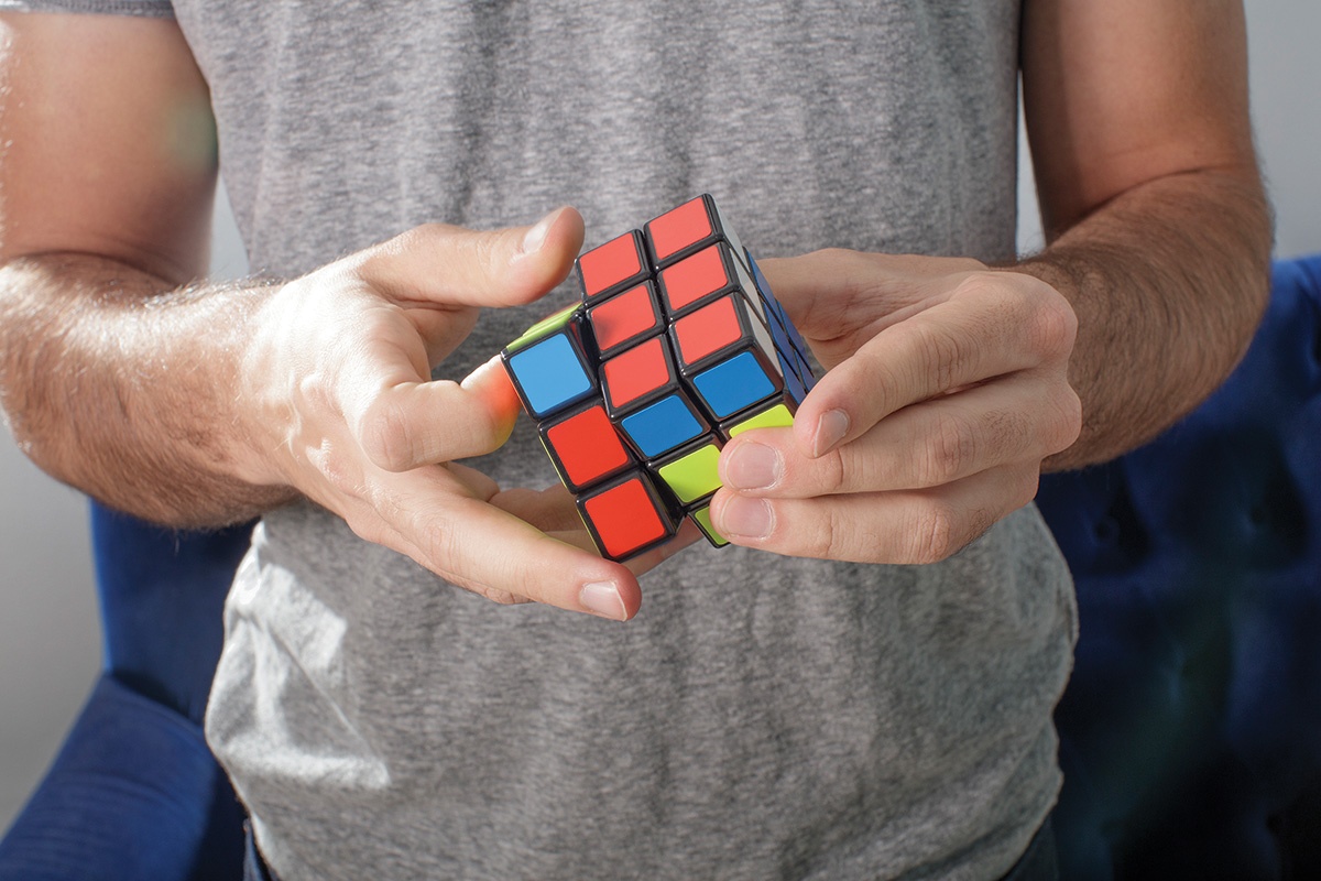 A photograph of Max Deutsch's hands playing with a Rubik's Cube.