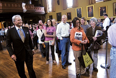Photo of Tom Brokaw standing by students.