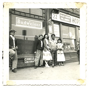 Vintage photo of five people standing against a storefront.