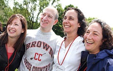 Photo of four people standing, one in a Brown sweatshirt.