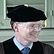 Photo of a man in a commencement cap smiling.