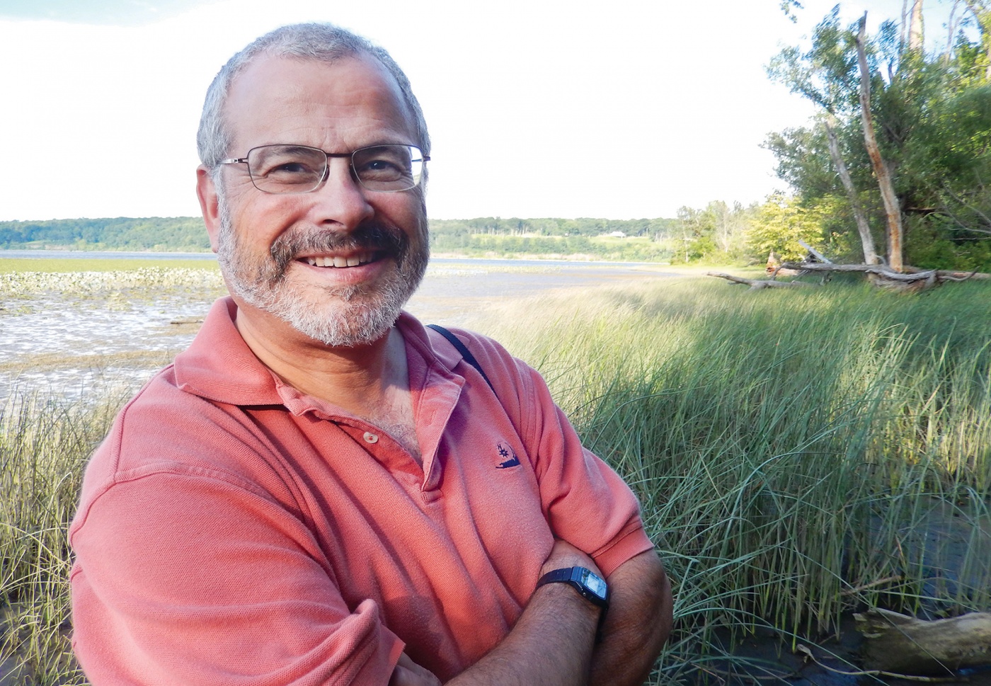 Photo of Joel Scheraga, with wetlands in the background.