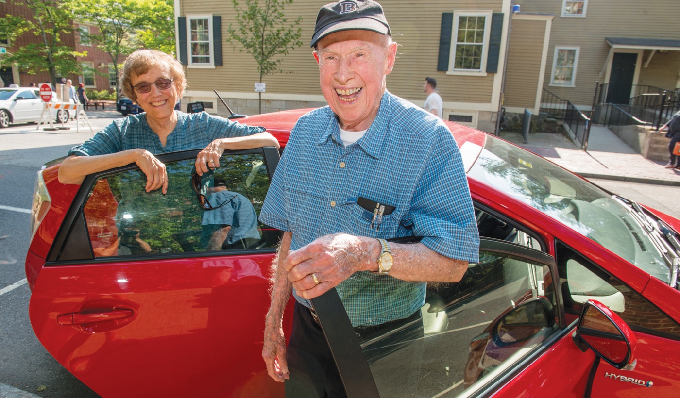 Photo of Bob Traill ’43 and Judy Andrews Green ’68 in front of a car.