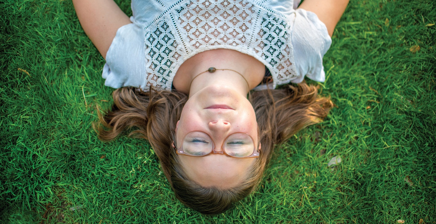 A student rests on the grass