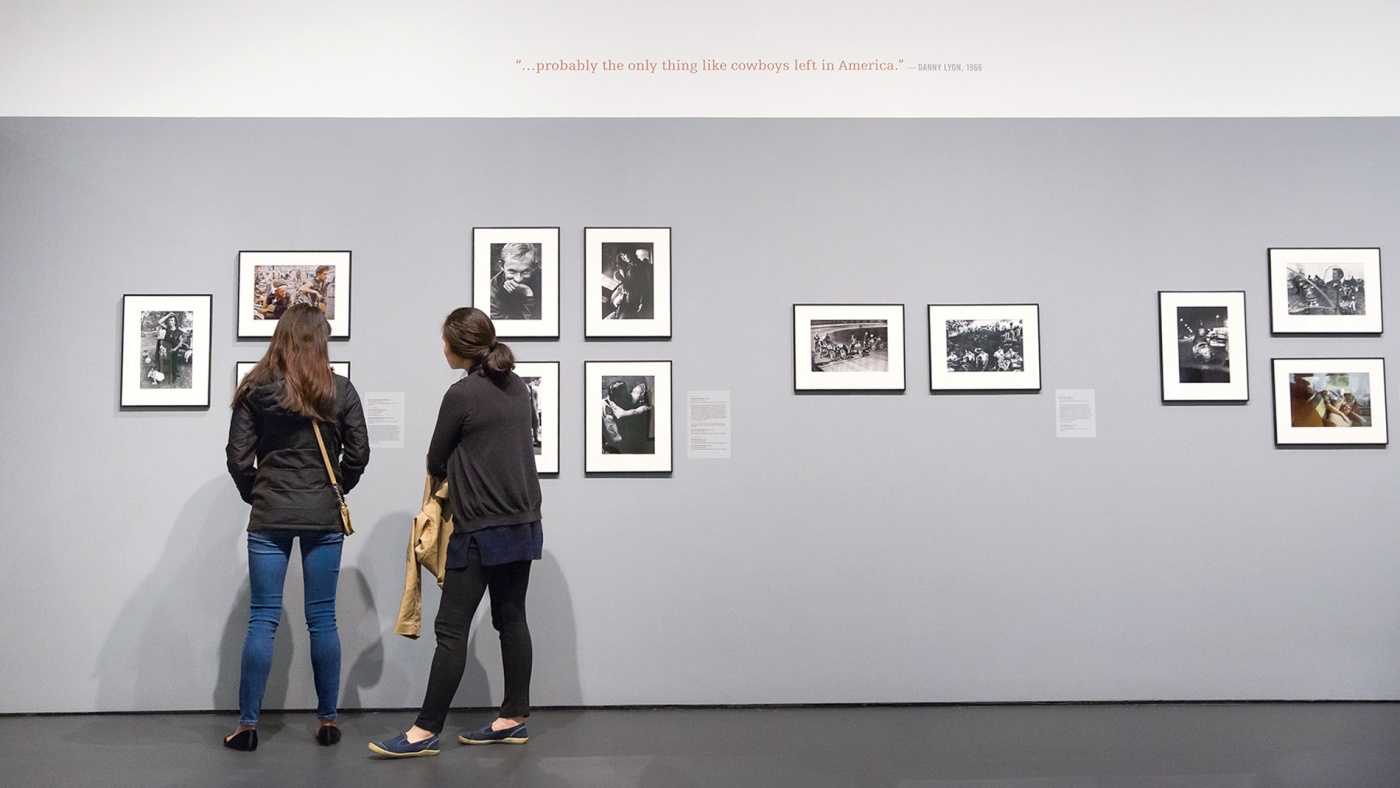 Two women look at Danny Lyons' photos in the Bell Gallery