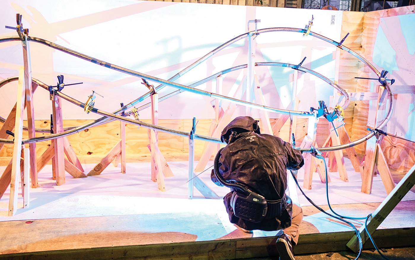 Photograph of a student welding the sculpture