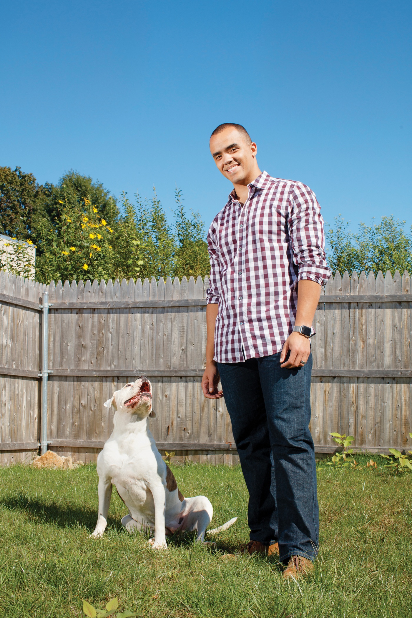 Photo of former Marine Michael Muir ’20 and his dog Sasha B. Muir enjoy their yard in North Providence. 