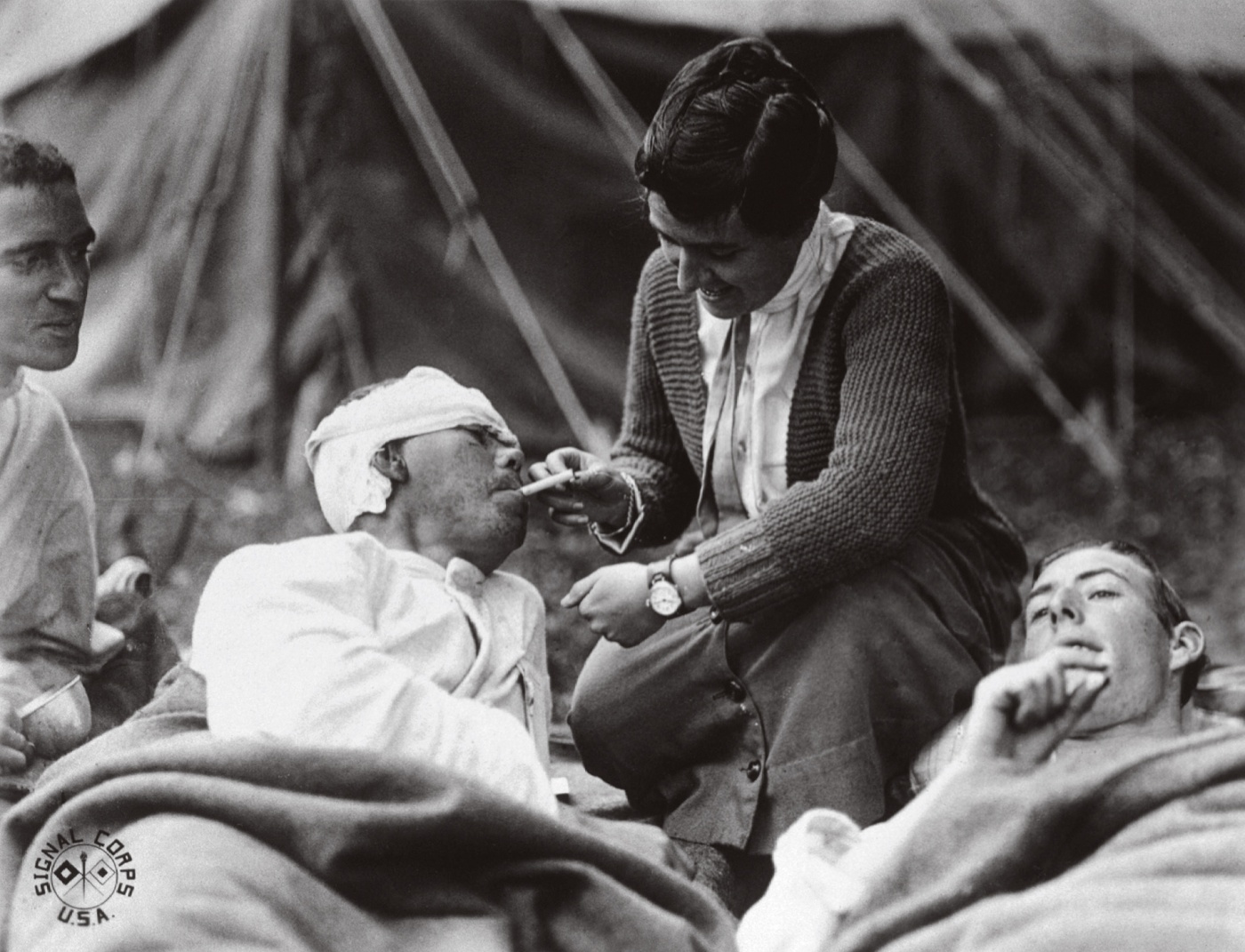 A WWI nurse administers to wounded soldiers