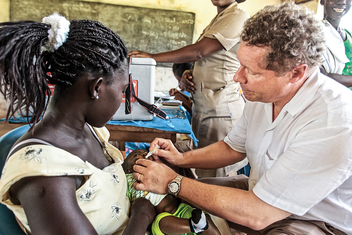 Seth Berkley ’78, ’81 MD administers the rotavirus vaccine to an infant in Ghana in 2012.