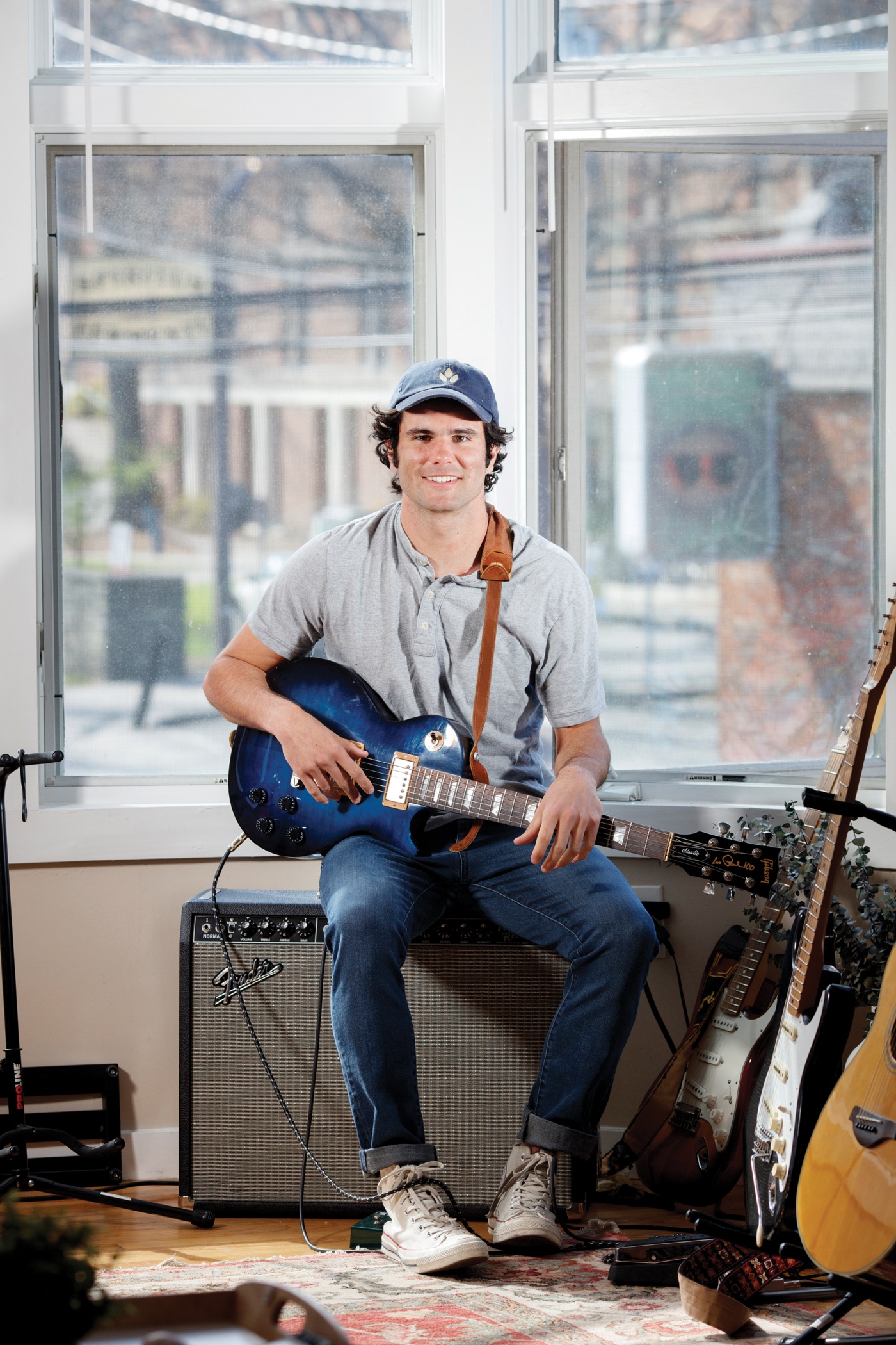 Aidan Reilly playing guitar in his dorm room.