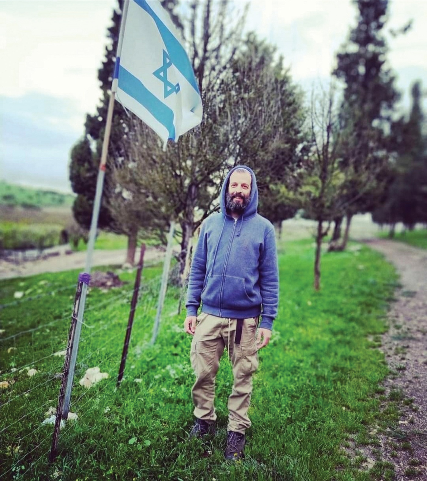 Image of Akiva Gersh standing next to the Israeli flag