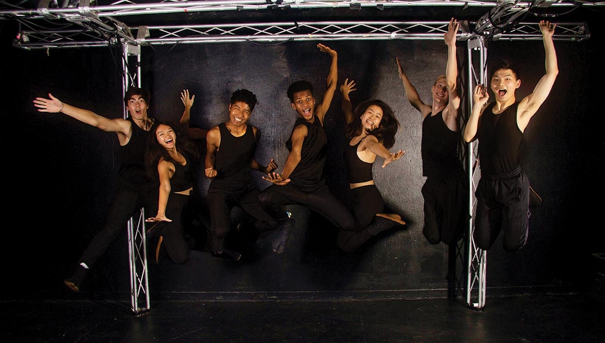 Image of Brown's Gendo Kaiko team all dressed in black jumping up in the air.