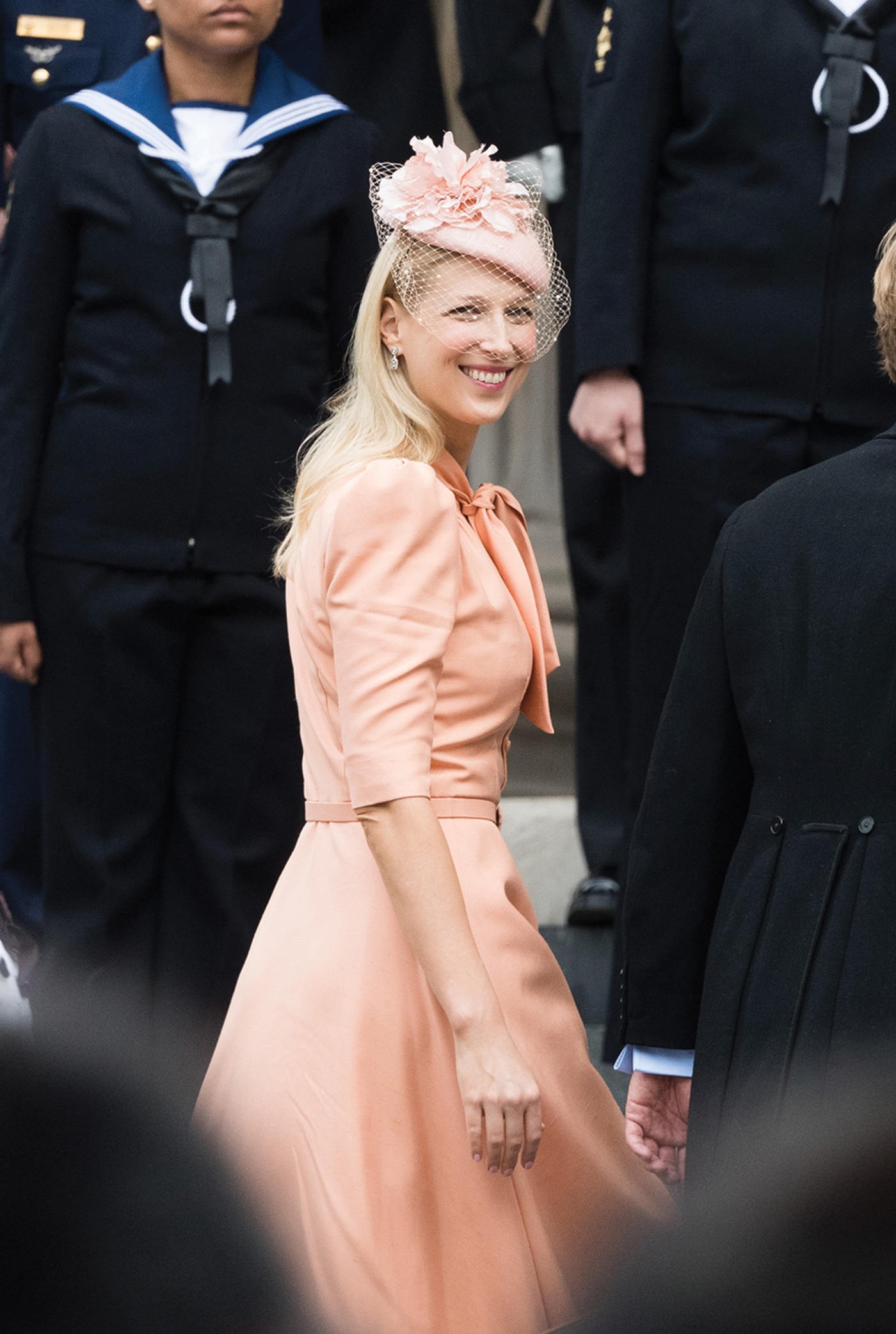 Image of Lady Gabriella Windsor dressed in pink looking back at the camera and smiling.