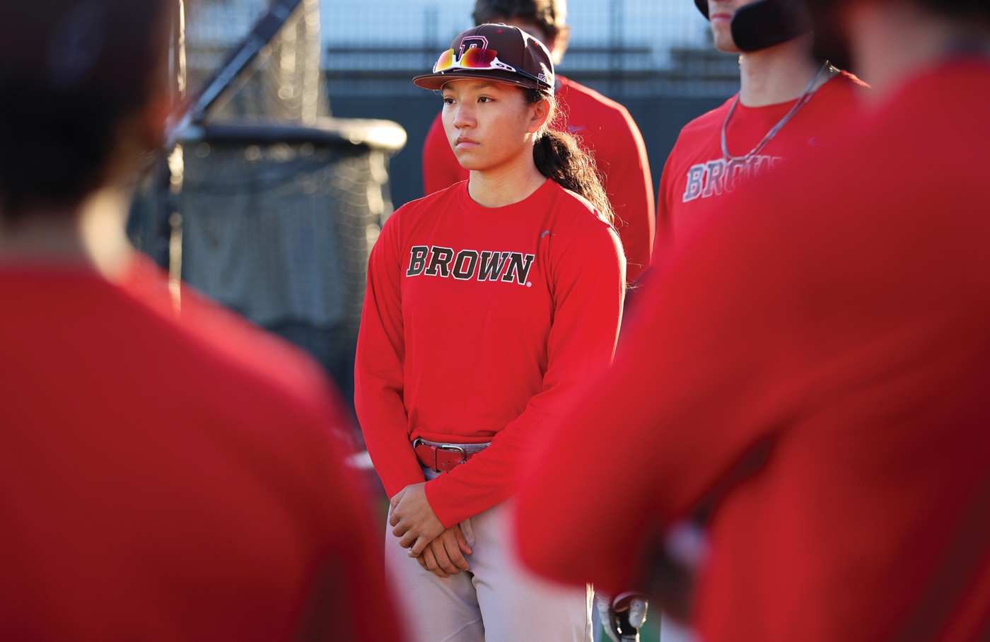 Image of Olivia Pichardo in Brown baseball uniform standing with her teammates.