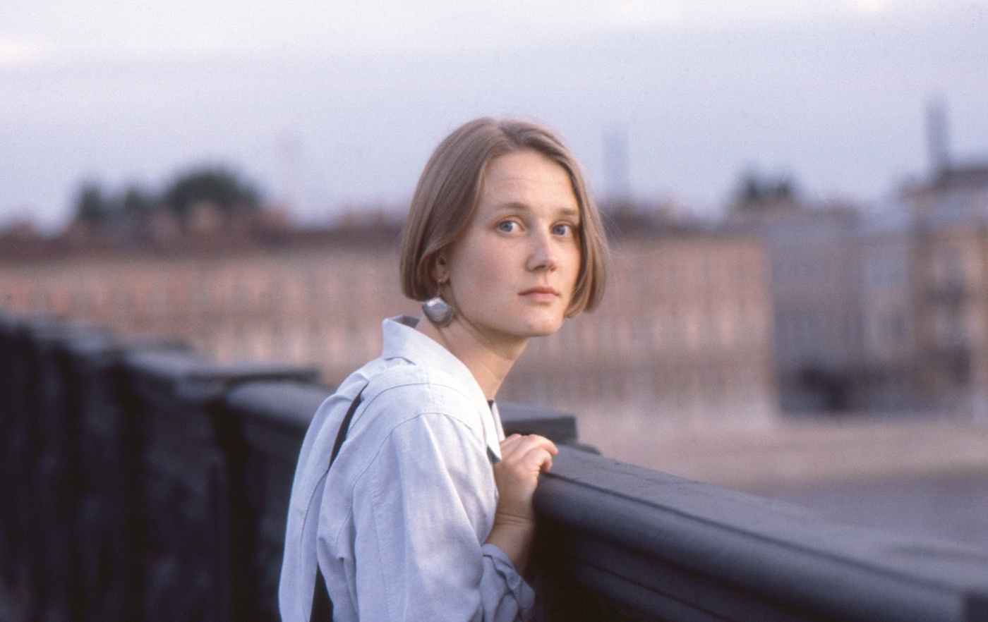 Image of a young Mari Ruti standing on a bridge in Europe looking back.