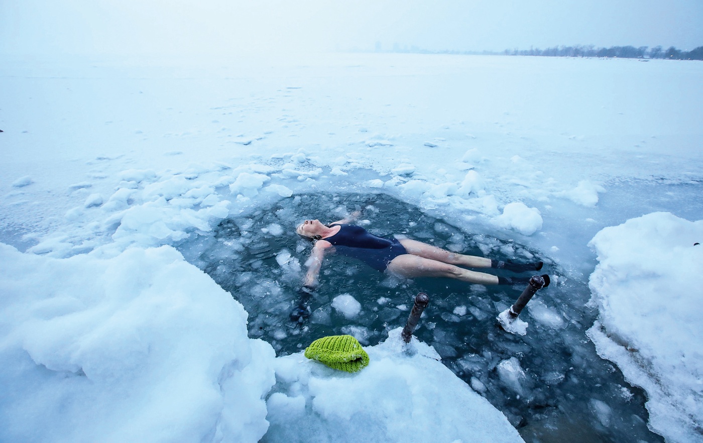 Photo by Stacey Westcott of Helen Wagner with a hat on coming up out of icy water.