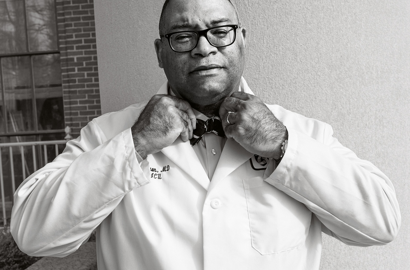 Archival black and white image of Galen Henderson tying a bowtie.