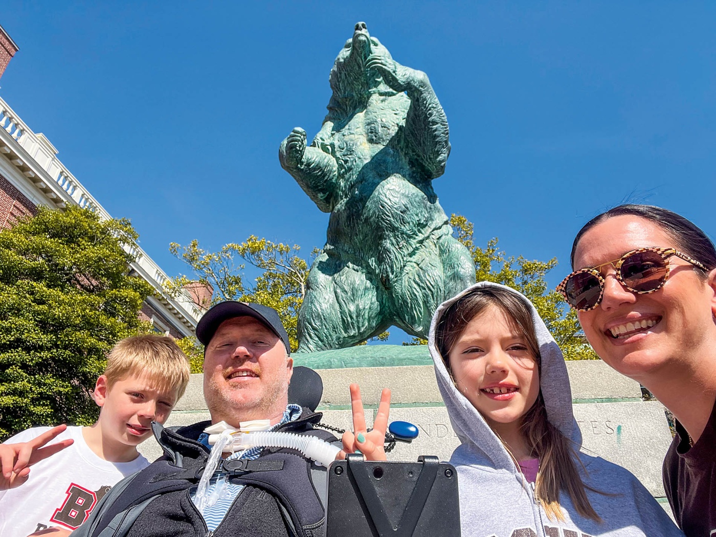 Close-up image of Nate Poole and family in front of Bronze Bruno on Brown University Campus