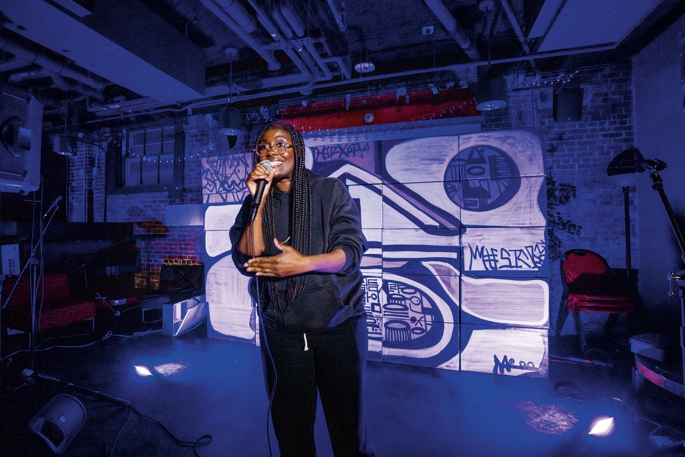 An image of Sammus on stage with a microphone