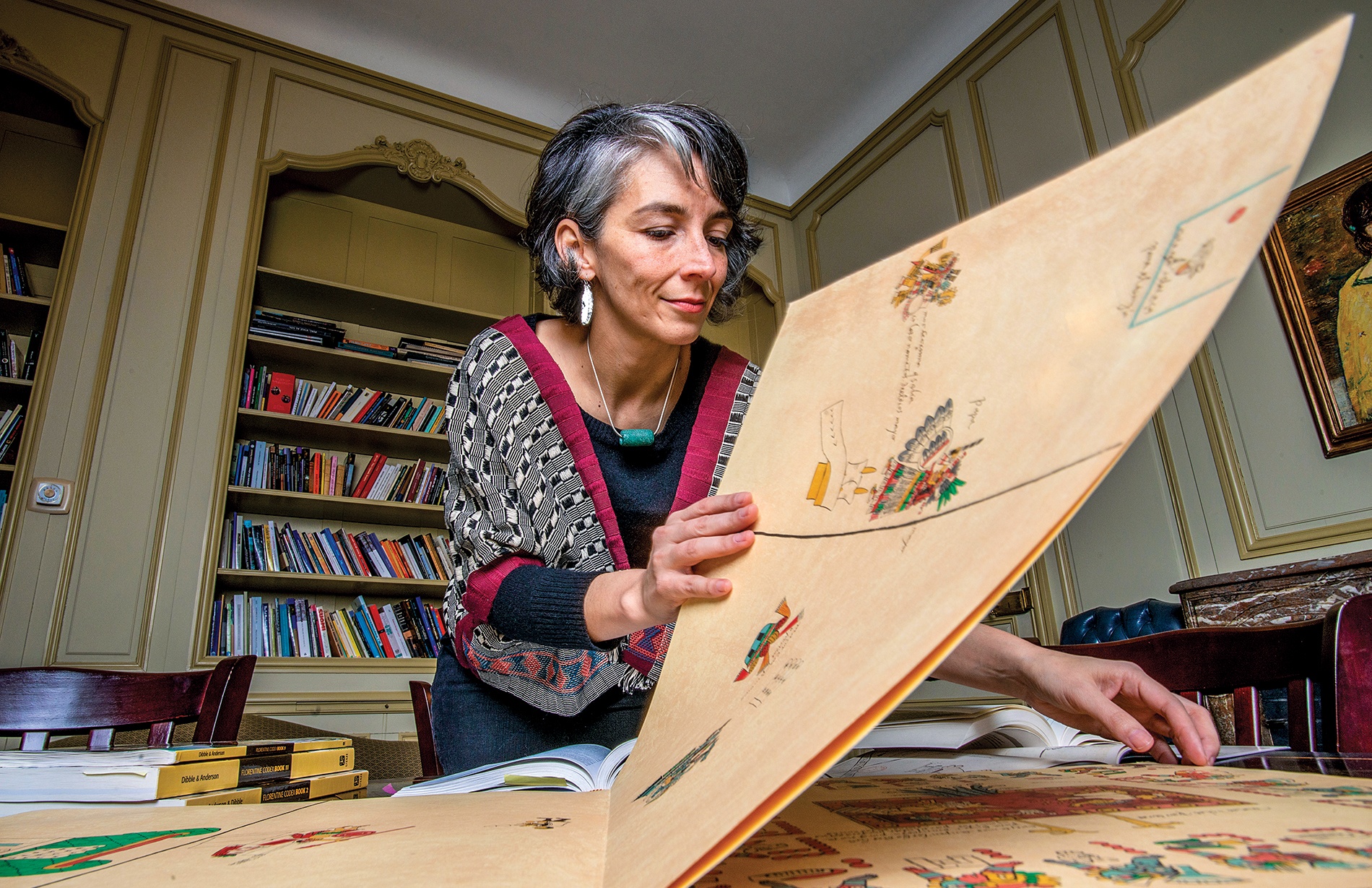 Prof Iris Montero leafing through a folio