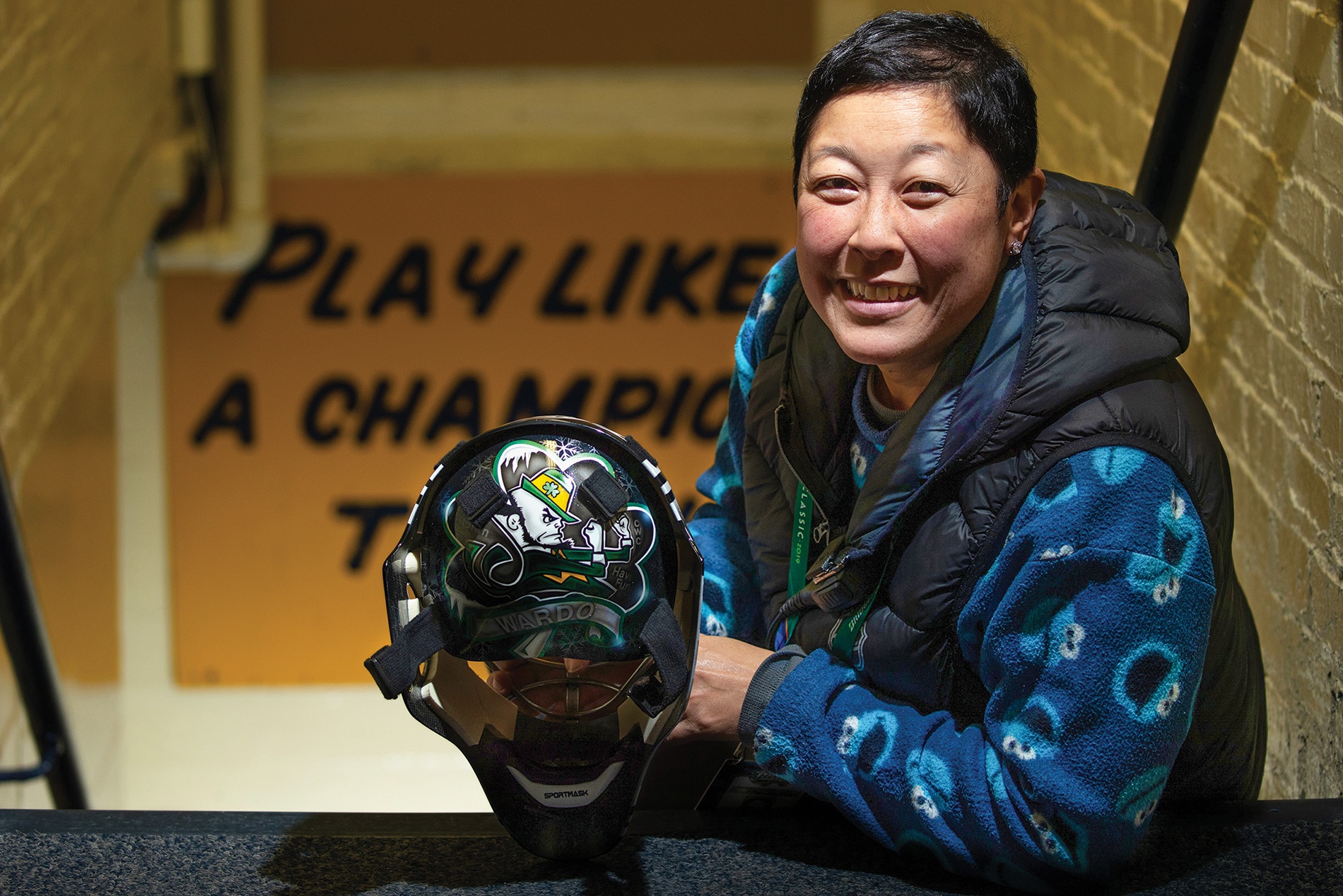 Image of Chie Chie Yard in a stairwell holding a hockey helmet