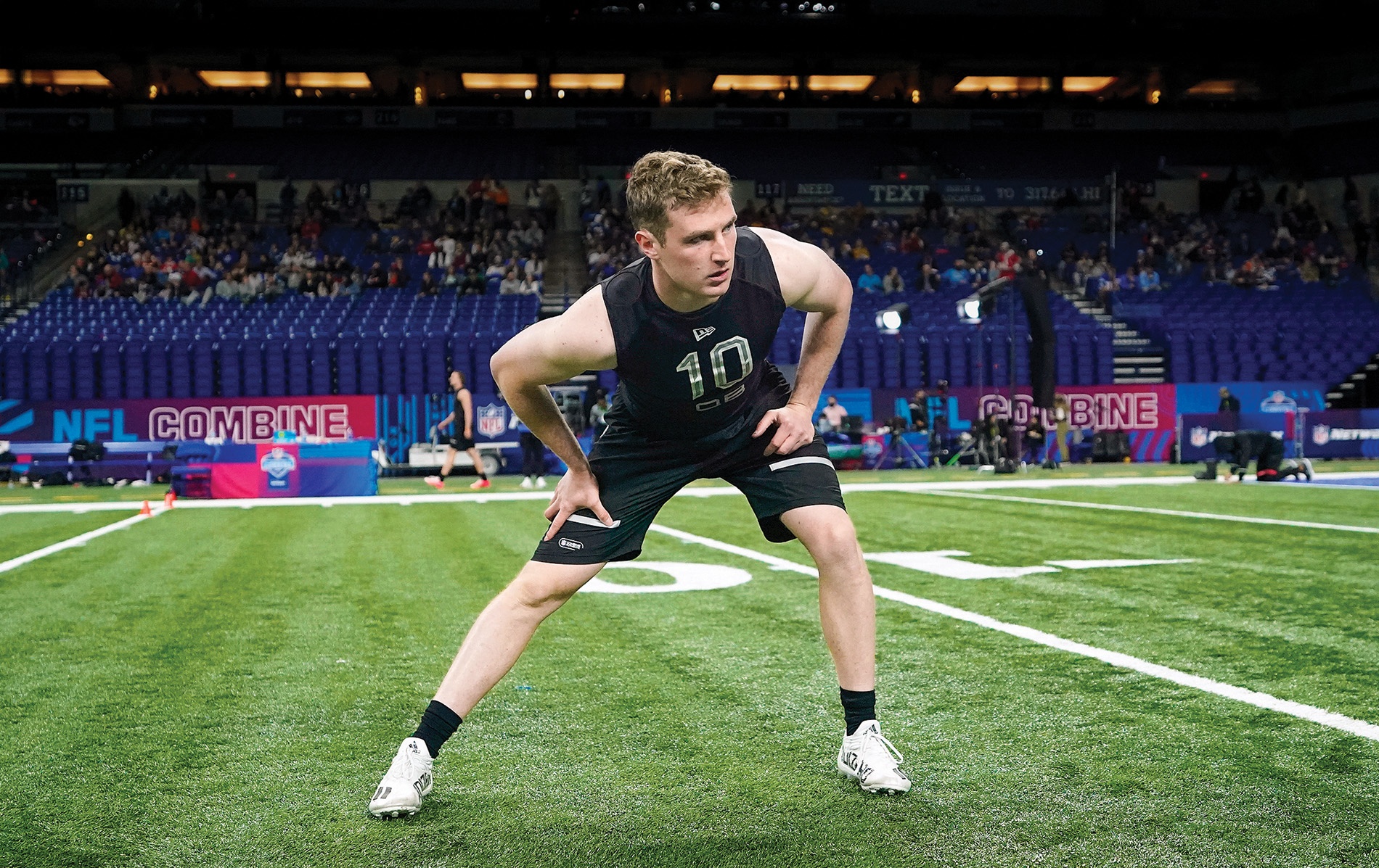 Image of EJ Perry stretching on football field