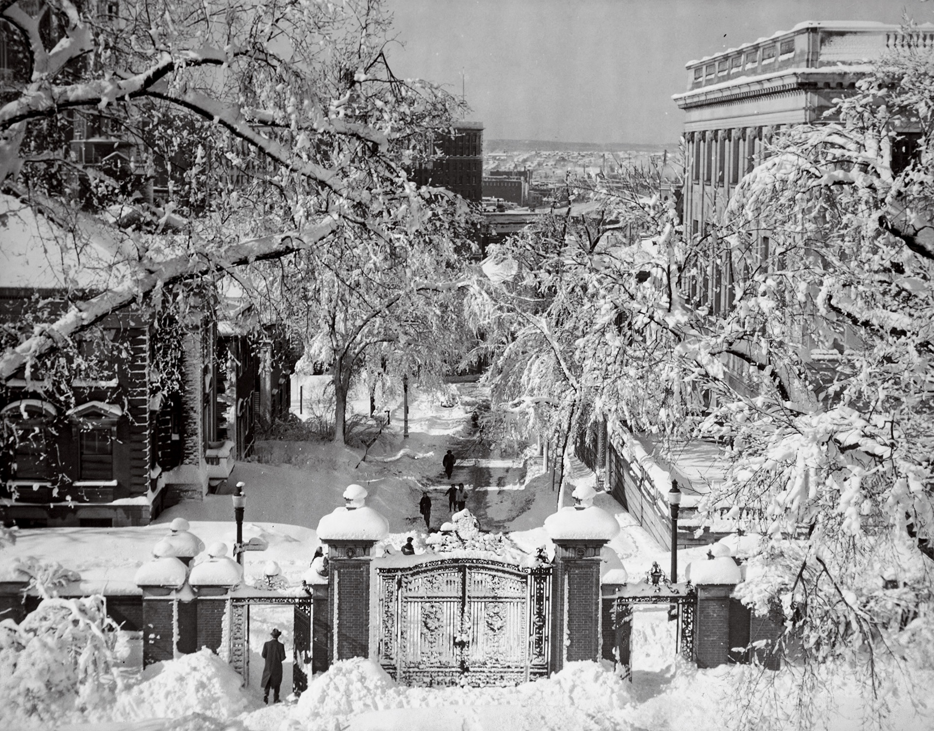 Image of the Van Wickle gates covered in snow in the early 20th century looking down College Hill