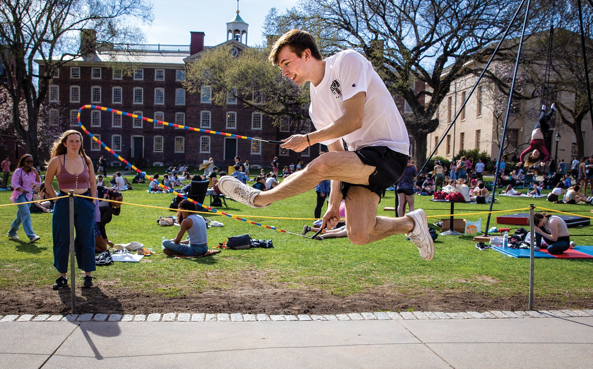 Image of Connor Kraska in-air jump-roping on the campus green.