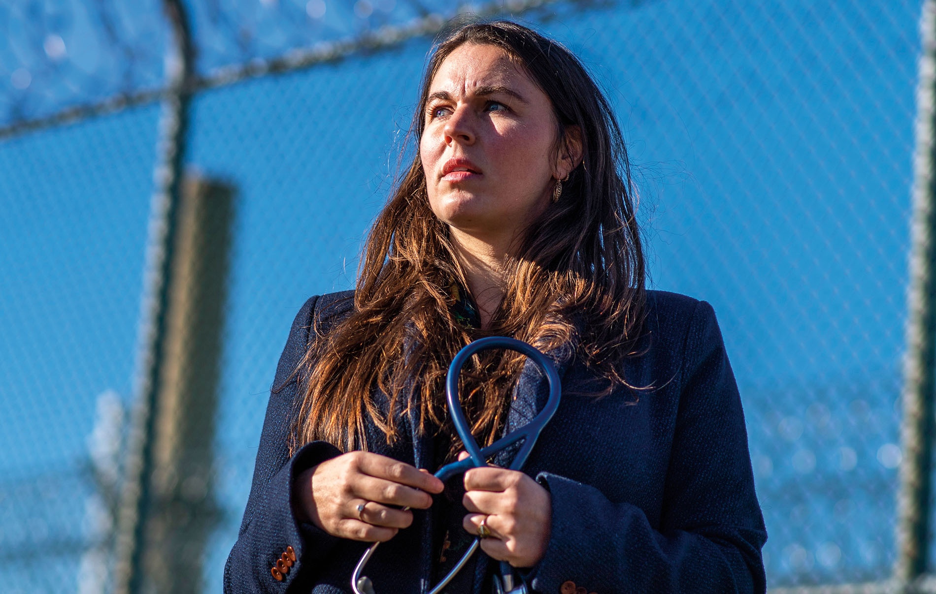 An image of Rachel Bedard holding a stethoscope outside of a prison