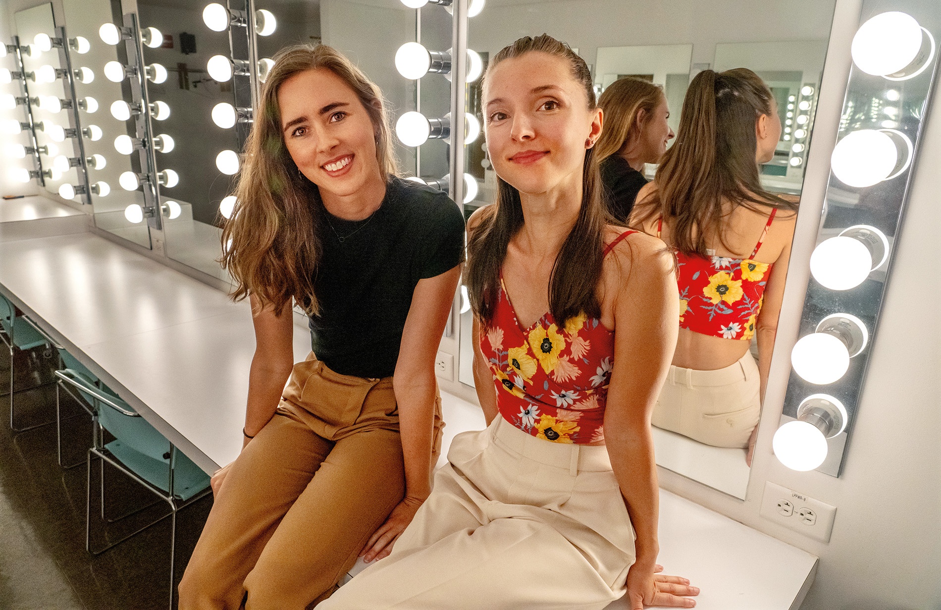Image of Kayleigh Donowski and Eugenia Zinovieva sitting in front of a lighted mirror