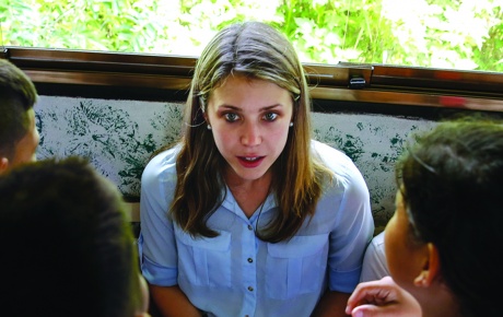 Image of Alexandra Ulmer taking notes, surrounded by Venezuelan children.